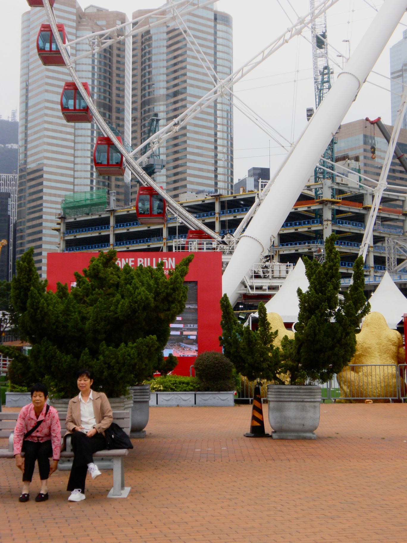 Two women resting beneath the Hong Kong observation wheel
